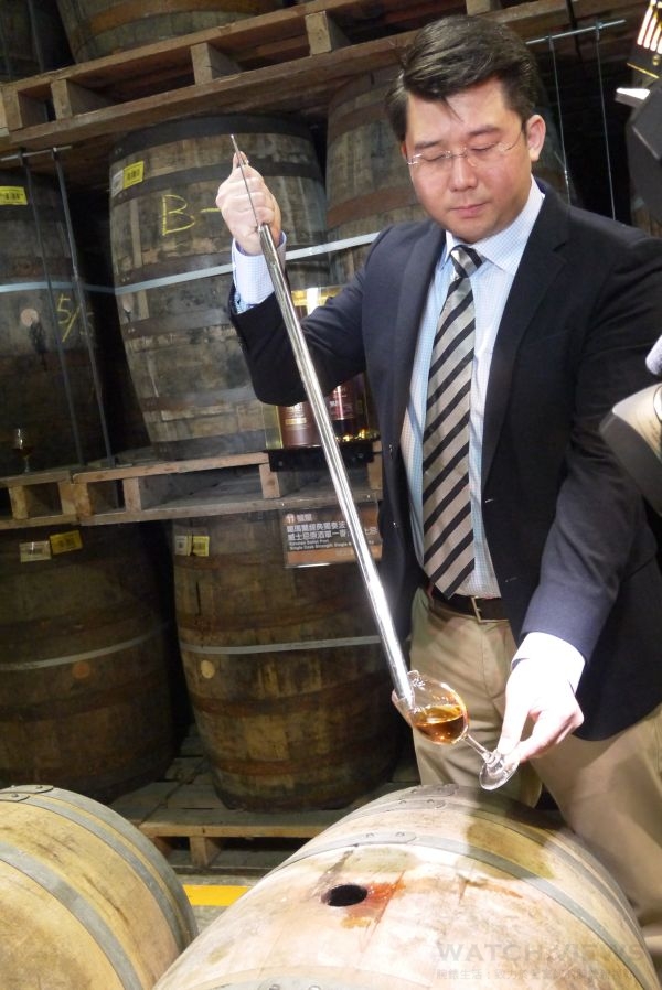 葛瑪蘭首席調酒師張郁嵐自波特桶取出一杯威士忌原酒。