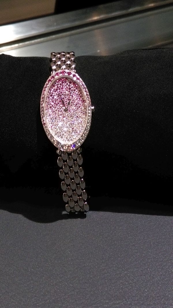 從日本櫻花景色為發想設計的腕錶，以粉紅剛玉、藍寶石與鑽石搭配漆飾珍珠母貝錶盤，透過對比色彩與分明層次創造神秘魅力。 