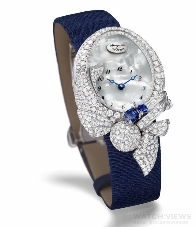 LES VOLANTS DE LA REINE 8924那不勒斯皇后的霓裳 高級珠寶錶錶殼以18K白金鑄造。錶圈及錶耳鑲有146顆圓形鑽石（約2.848克拉），錶盤凸緣鑲有66顆圓形鑽石（約0.132克拉），飾邊以雪花鑲嵌技術鑲有193顆圓形鑽石（約1.07克拉）、11顆長方形鑽石（約0.35克及兩顆墊形藍寶石（約0.59克拉），錶冠鑲有1 顆帶三角形琢面的梨形鑽石（約0.28克拉），球形飾件以雪花鑲嵌技術鋪鑲61顆圓形鑽石（約0.478克拉）。藍寶石水晶底蓋；尺寸33 x 24.95；貝母錶盤，鑲有20顆圓形鑽石（約0.02克拉）；緞錶帶配鑲有26顆圓形鑽石折叠錶扣；建議售價格NTD4,129,000。