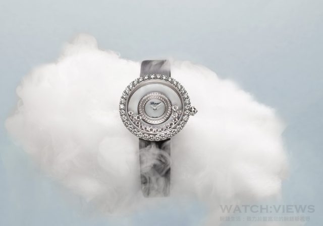 Happy Diamonds系列『40周年紀念腕錶』Happy Diamonds 18K白金材質腕錶，錶圈鑲有爪鑲鑽石，白色珍珠母貝錶面含有15顆兩種不同大小的滑動爪鑲鑽石，中圈鑲崁鑽石，搭配黑色絹絲錶帶。